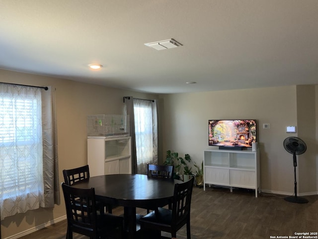 dining space featuring dark wood-style flooring, visible vents, and baseboards