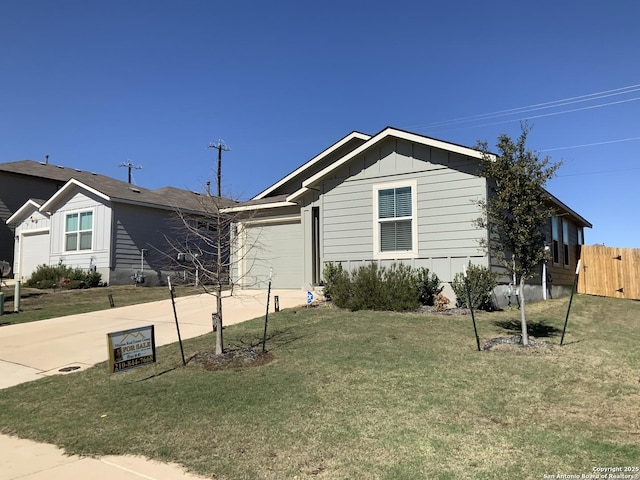 ranch-style house featuring an attached garage, board and batten siding, a front yard, fence, and driveway