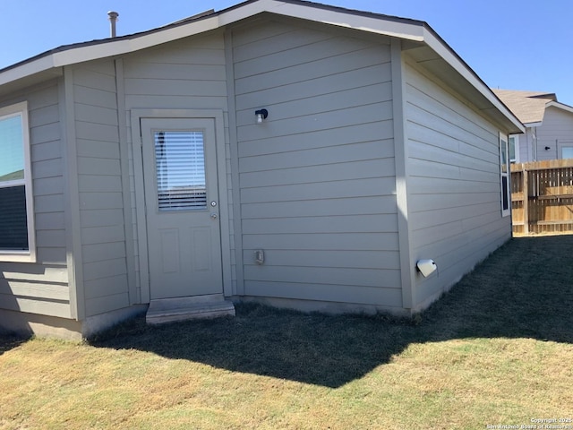 rear view of house featuring a yard and fence