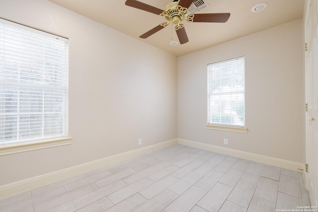 unfurnished room with a ceiling fan and baseboards