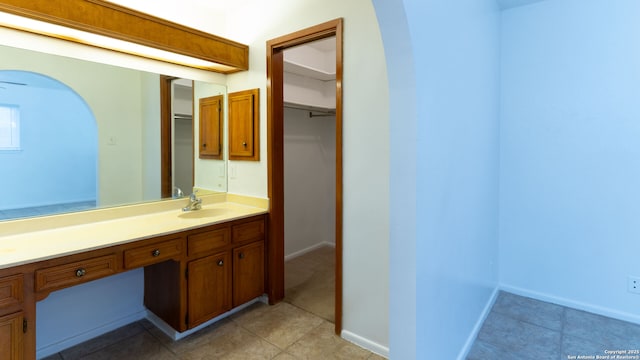 bathroom with vanity, baseboards, and tile patterned floors