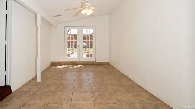 spare room featuring french doors, lofted ceiling, visible vents, a ceiling fan, and light tile patterned flooring