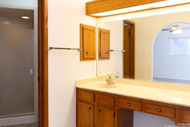 full bath featuring ceiling fan, a shower stall, and vanity