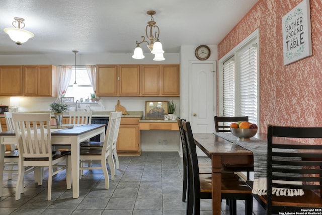 kitchen with a notable chandelier, light countertops, hanging light fixtures, and wallpapered walls