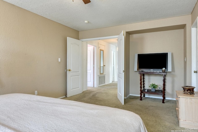 bedroom featuring a ceiling fan, light colored carpet, baseboards, and a textured ceiling