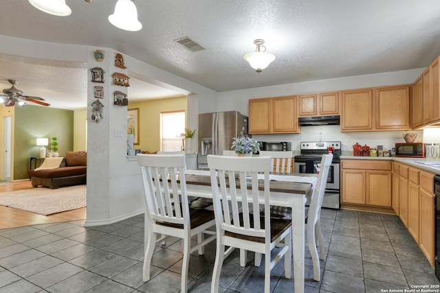 kitchen featuring a textured ceiling, visible vents, light countertops, under cabinet range hood, and appliances with stainless steel finishes