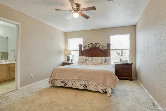 bedroom featuring baseboards, a textured wall, light colored carpet, and a textured ceiling