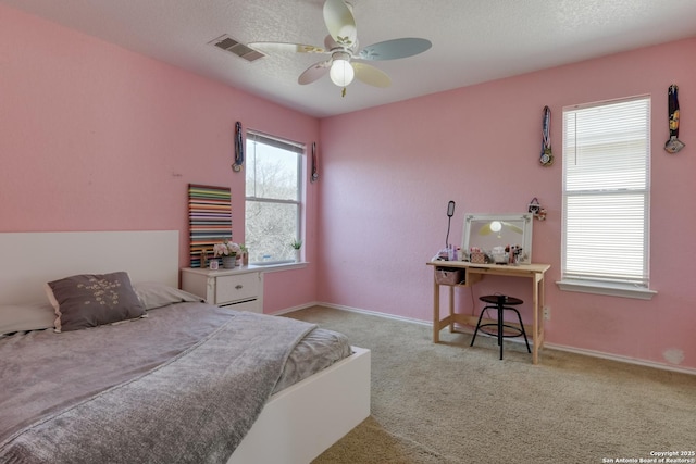 carpeted bedroom with ceiling fan, baseboards, visible vents, and a textured ceiling