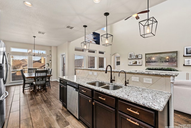 kitchen featuring visible vents, arched walkways, dark wood-style floors, appliances with stainless steel finishes, and a sink