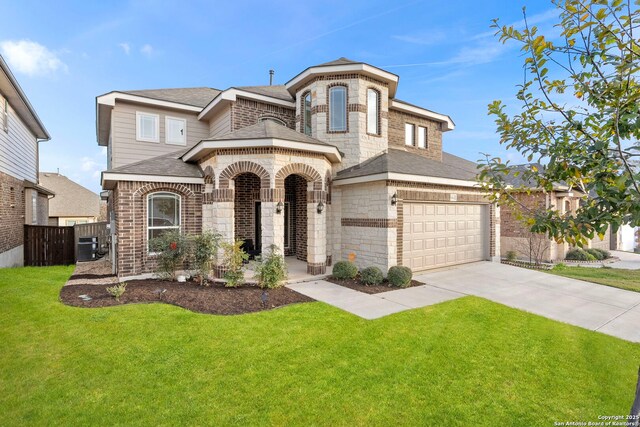 french country style house with driveway, stone siding, an attached garage, a front yard, and brick siding