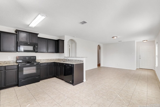 kitchen with visible vents, arched walkways, a peninsula, black appliances, and a sink