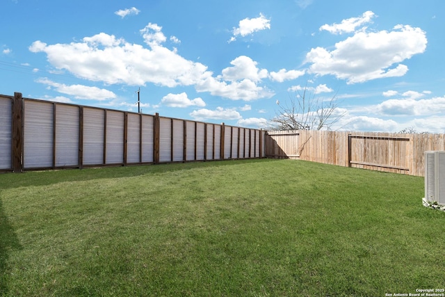 view of yard with a fenced backyard and central air condition unit