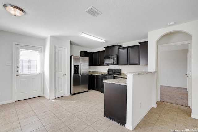 kitchen featuring light tile patterned floors, a textured ceiling, arched walkways, visible vents, and black appliances