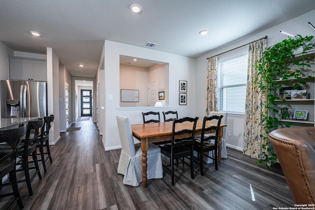 dining room featuring baseboards, visible vents, dark wood finished floors, and a wealth of natural light