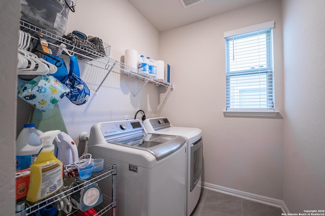 laundry area featuring visible vents, separate washer and dryer, dark tile patterned flooring, laundry area, and baseboards