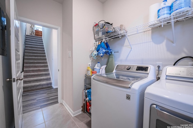 laundry room featuring washer and dryer, laundry area, baseboards, and light tile patterned floors