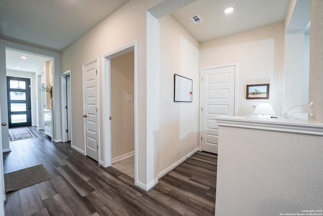 hall with dark wood-style flooring, recessed lighting, visible vents, and baseboards