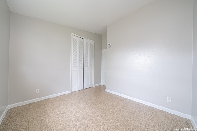 unfurnished bedroom with a closet, baseboards, and tile patterned floors