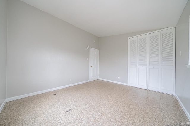 unfurnished bedroom with a closet, baseboards, and tile patterned floors