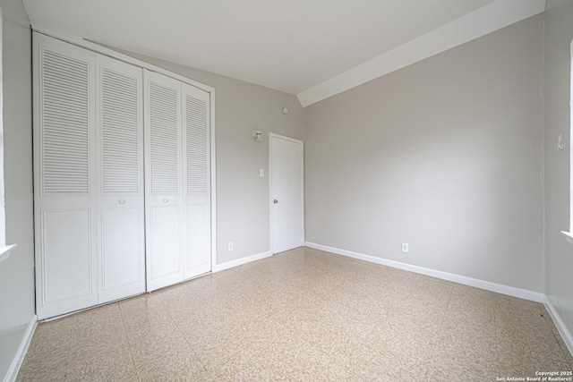 unfurnished bedroom with baseboards and a closet