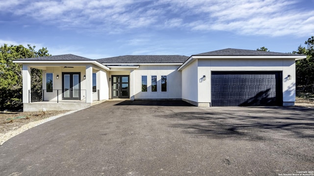 view of front of property with aphalt driveway, french doors, ceiling fan, and a garage