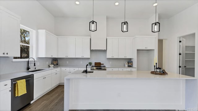 kitchen featuring dishwashing machine, tasteful backsplash, a sink, and white cabinets