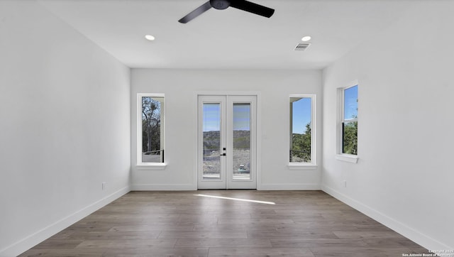 unfurnished room featuring recessed lighting, baseboards, wood finished floors, and french doors