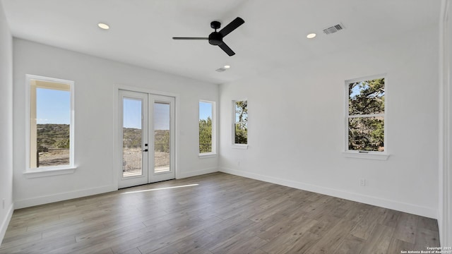 unfurnished room with recessed lighting, visible vents, plenty of natural light, and wood finished floors