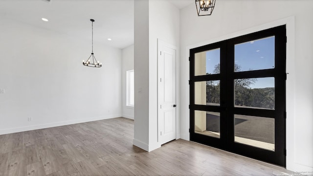 foyer with an inviting chandelier, baseboards, wood finished floors, and recessed lighting