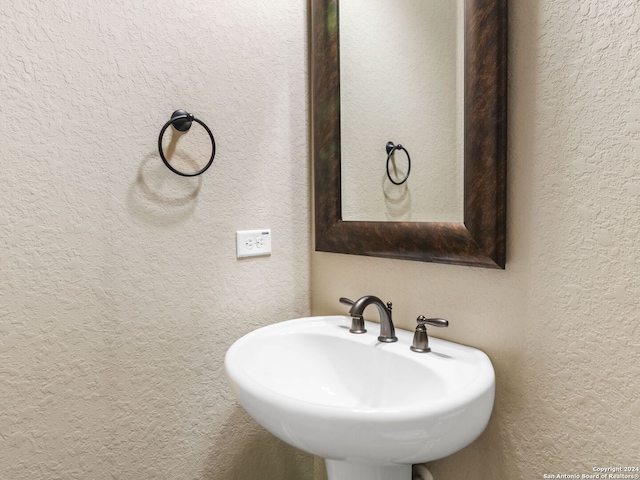 bathroom with a textured wall and a sink