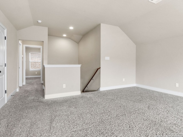 empty room featuring vaulted ceiling, carpet floors, recessed lighting, and baseboards