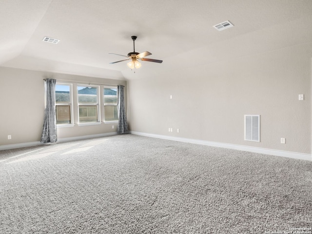 carpeted empty room featuring baseboards, visible vents, and vaulted ceiling