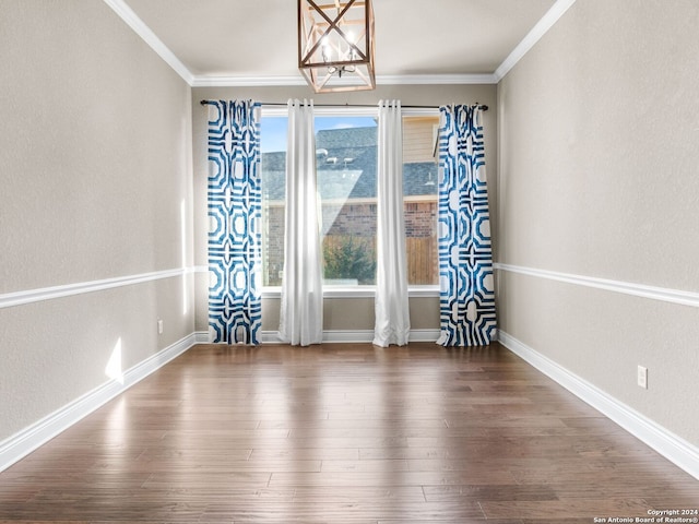 unfurnished dining area with ornamental molding, baseboards, and wood finished floors