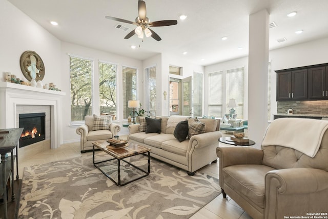 living area with a wealth of natural light, a tile fireplace, visible vents, and recessed lighting