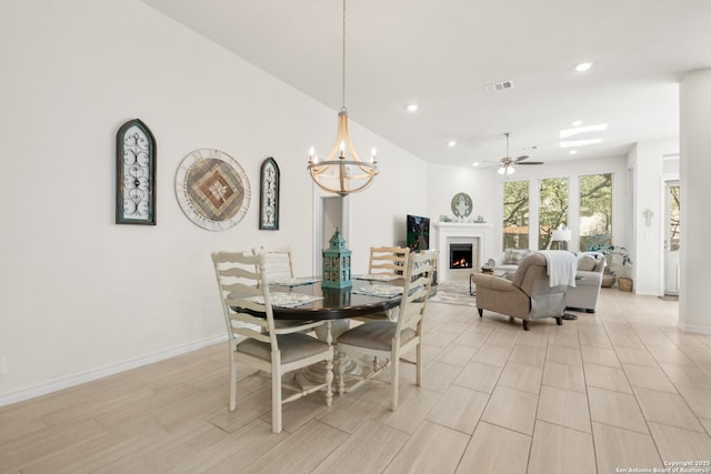 dining space with a warm lit fireplace, recessed lighting, visible vents, and baseboards