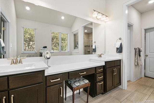 full bath with double vanity, a shower stall, a sink, and recessed lighting