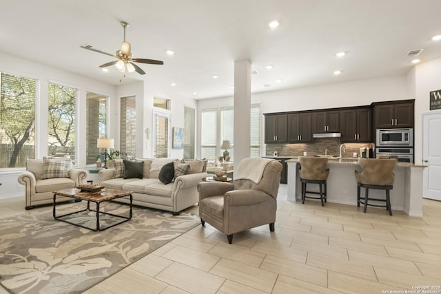 living area featuring ceiling fan, visible vents, and recessed lighting