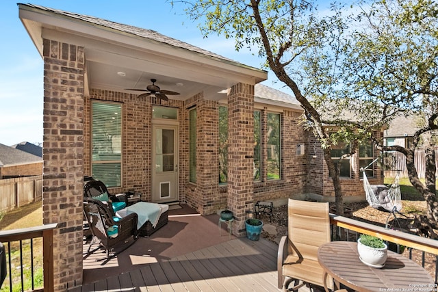 wooden terrace with a ceiling fan and fence