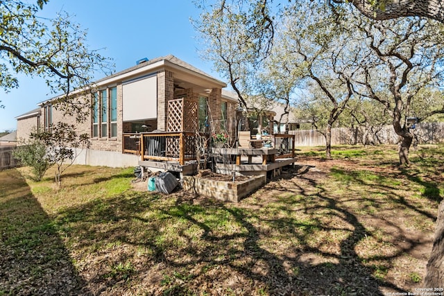 rear view of house with a yard, a fenced backyard, brick siding, and a deck