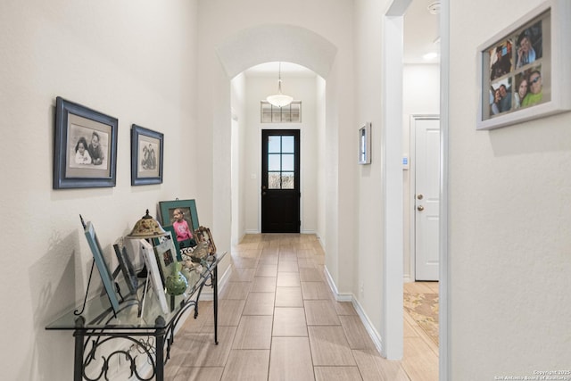 entrance foyer with baseboards and arched walkways