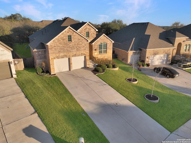 view of front facade with a garage, brick siding, fence, concrete driveway, and a front yard