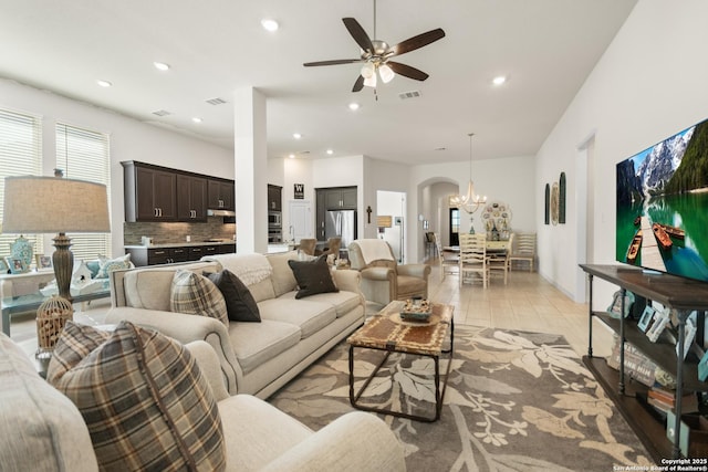 living room featuring ceiling fan with notable chandelier, arched walkways, visible vents, and recessed lighting