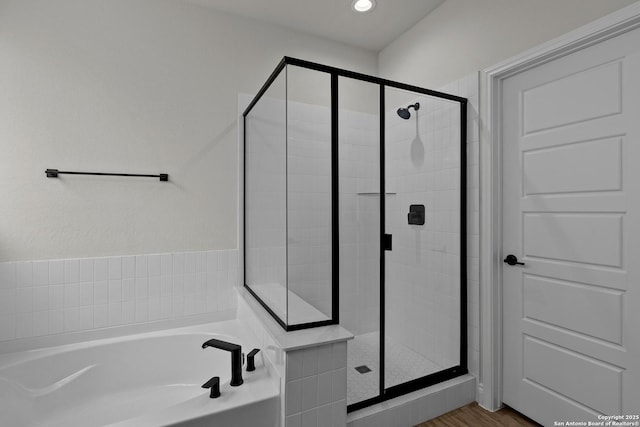 bathroom featuring recessed lighting, a garden tub, and a shower stall