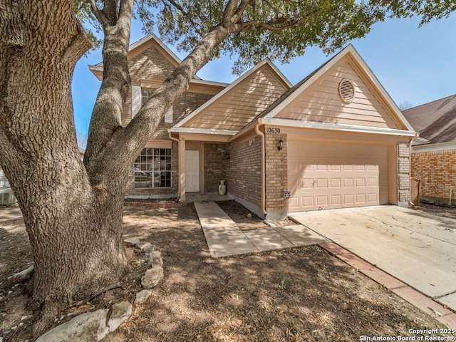 view of front facade featuring an attached garage, concrete driveway, and brick siding