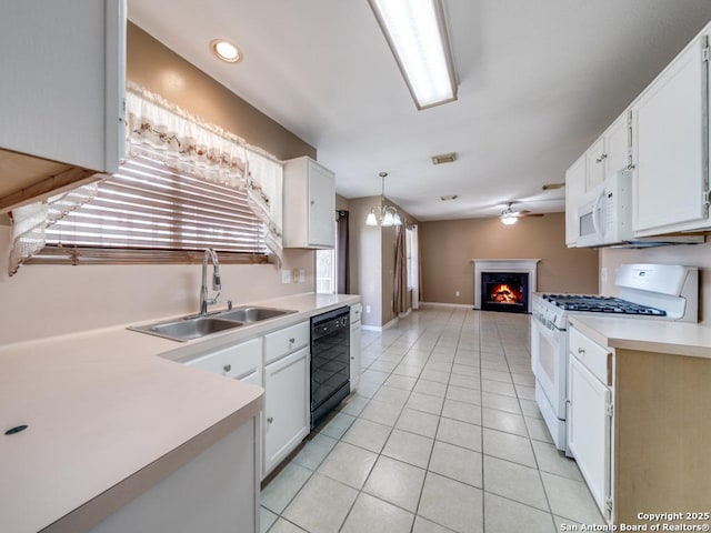 kitchen with visible vents, open floor plan, a sink, a warm lit fireplace, and white appliances