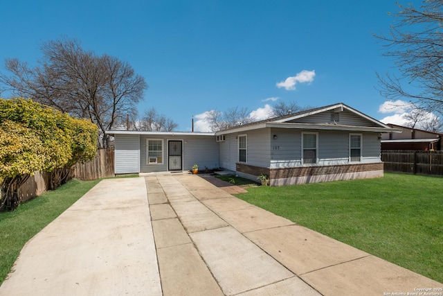 view of front of property with driveway, brick siding, a front yard, and fence