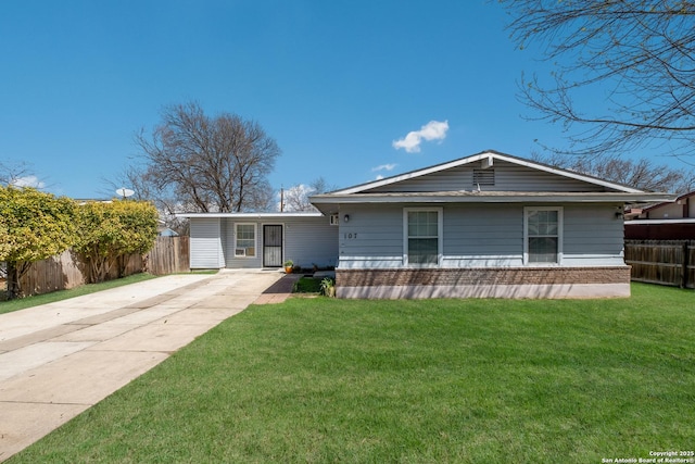 view of front facade featuring a front yard, brick siding, fence, and driveway