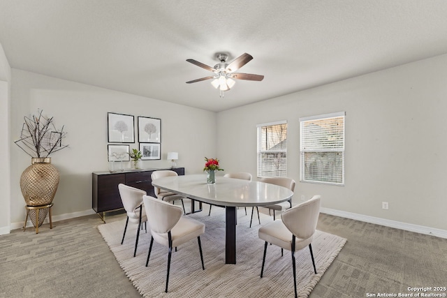 dining space with ceiling fan, baseboards, and light colored carpet