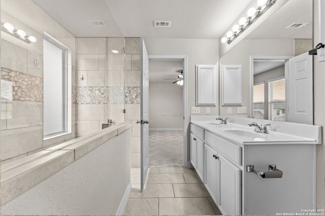 full bath with double vanity, visible vents, a sink, a walk in shower, and tile patterned flooring