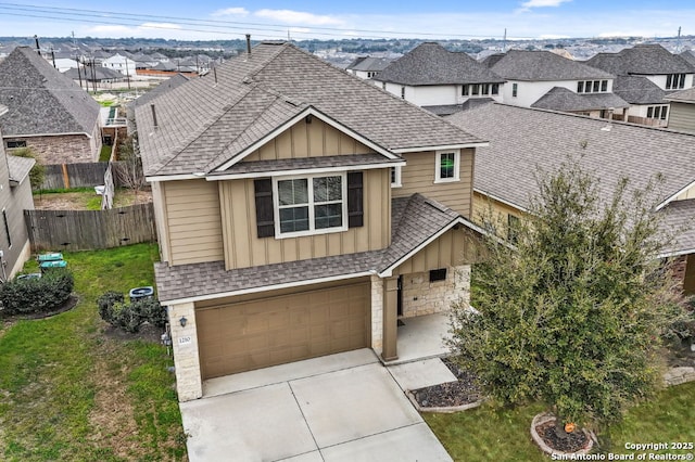 view of front facade with a shingled roof, fence, concrete driveway, a residential view, and board and batten siding